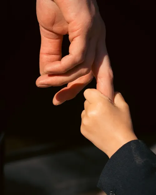 Kinderhand pakt de vinger van een volwassene vast